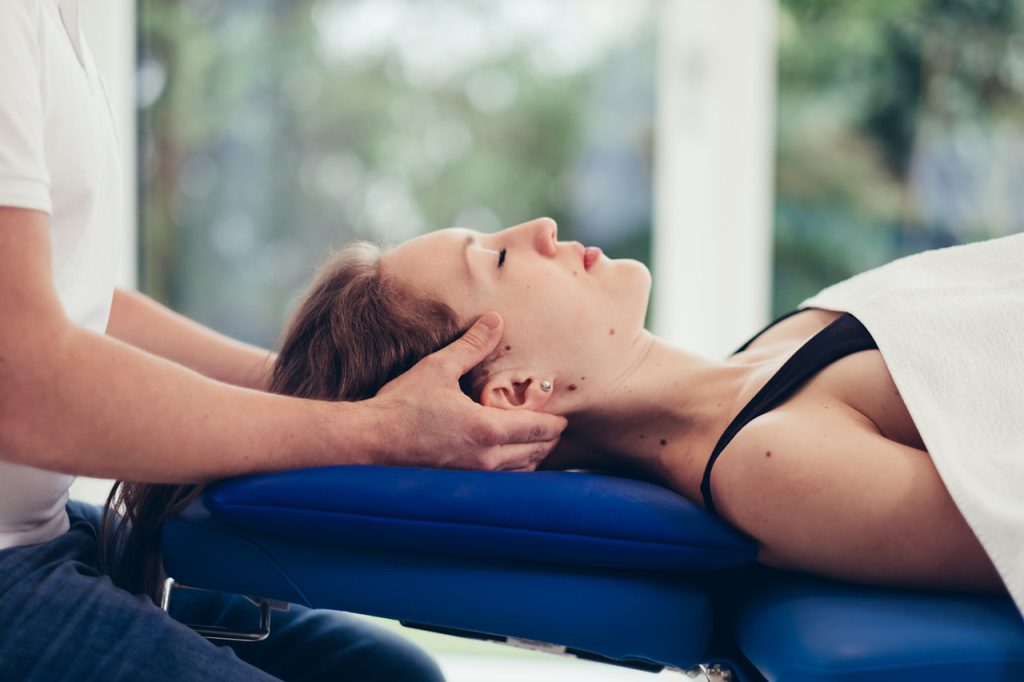 Physiotherapeut und Mentaltrainer Bernhard Hagspiel behandelt eine Patientin mit Verspannungen und Rückenschmerzen in seiner Praxis in Salzburg