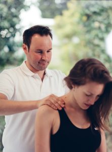 Physiotherapeut und Mentaltrainer Bernhard Hagspiel behandelt eine Patientin mit Verspannungen und Rückenschmerzen in seiner Praxis in Salzburg